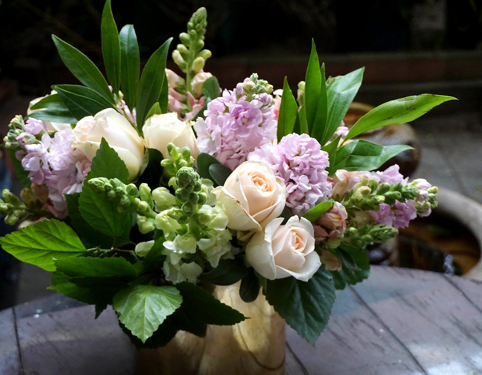 Blush roses, pink stock and snapdragons in a gold vase