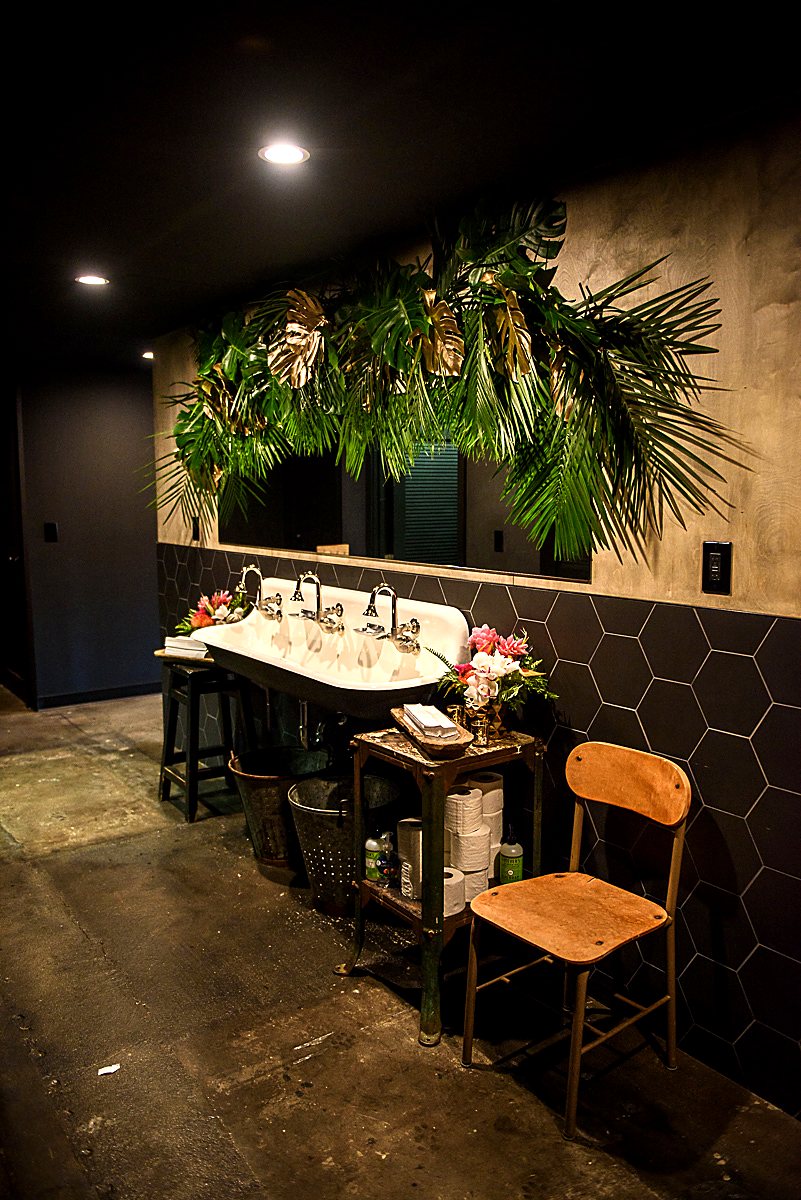 Tropical leaf and palm garland hanging above a restaurant restroom sink
